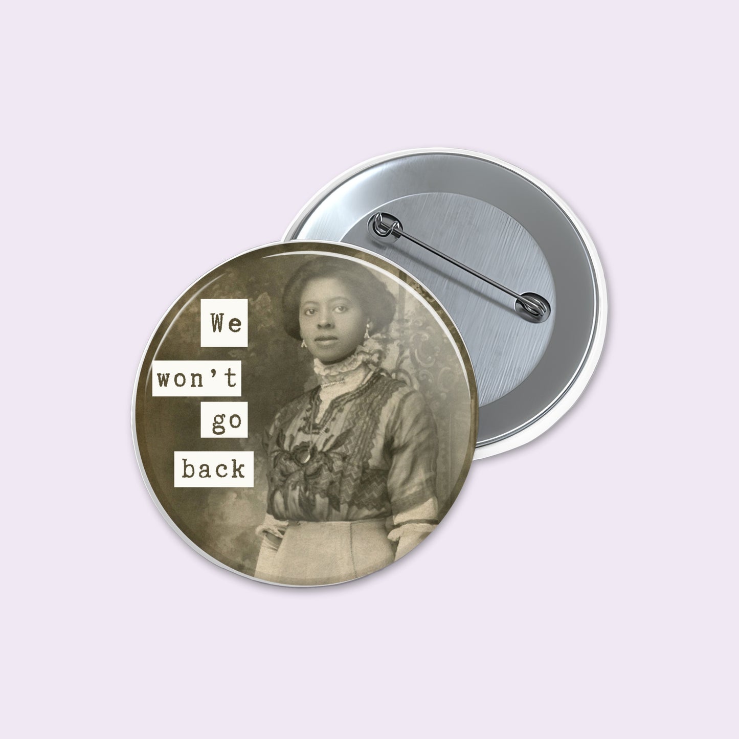 Round pinback button shows a sepia-toned vintage portrait of a woman with the text 'We won't go back' in white letter blocks.