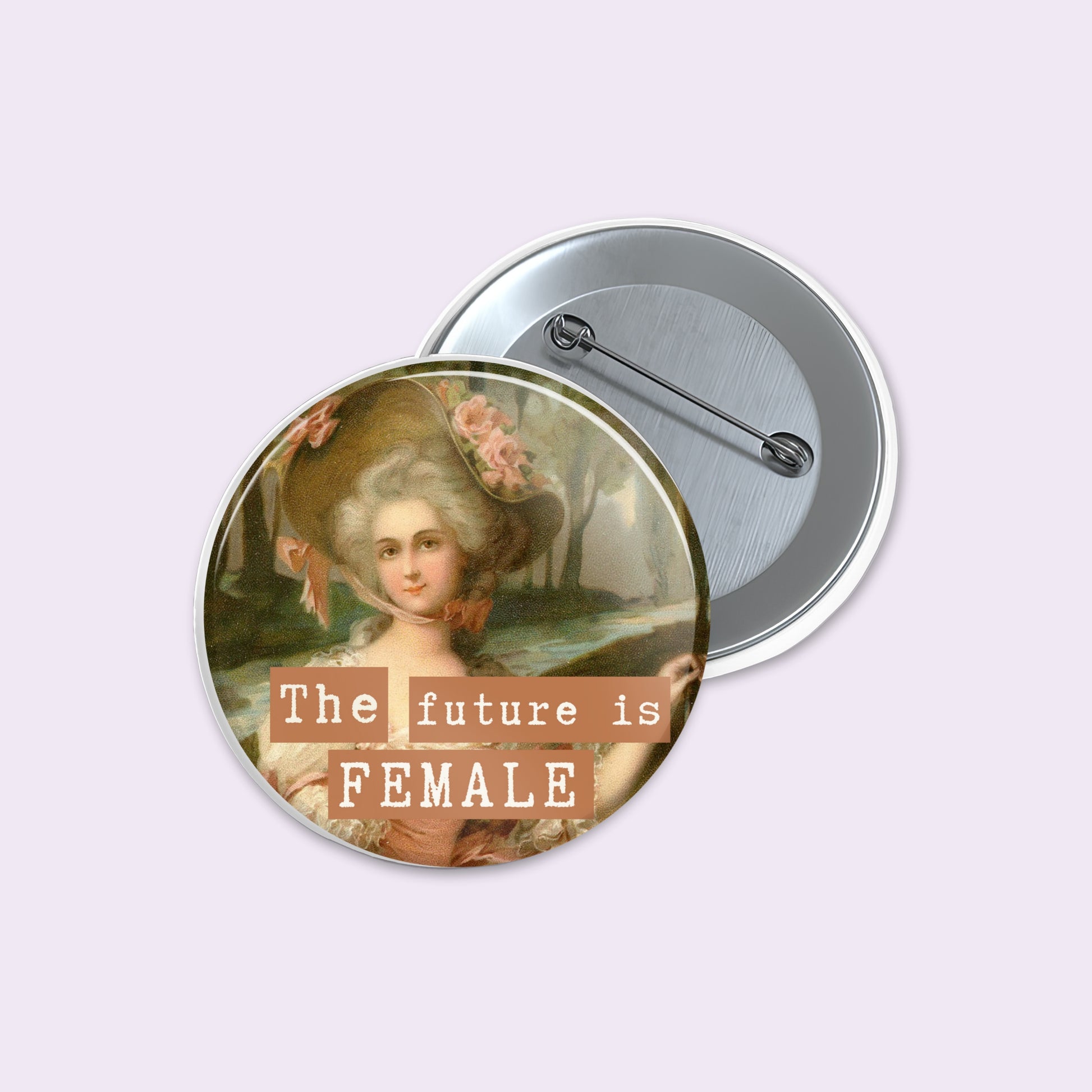 A round pin-back button shown from both front and back. The front features a vintage-style portrait of a woman in an ornate hat with the text 'The future is FEMALE' overlaid in white lettering on tan blocks.