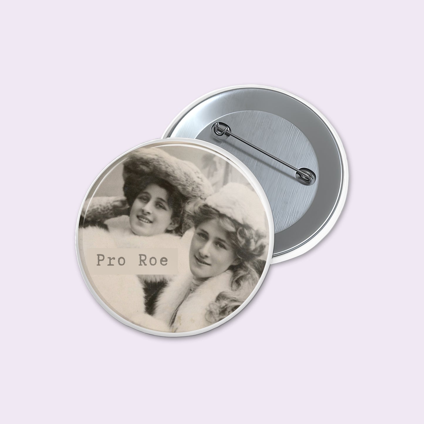 Button badge with vintage-style photograph of two women and 'Pro Roe' text on a light purple background.