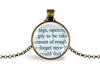 Round glass pendant showing printed book text set under a glass cabochon and into a bronze-plated bezel