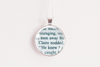 Round silver-toned pendant with upcycled book page text on a white background