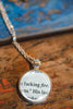 Upcycled book page pendant necklace with pendant featuring book page text on a wooden surface