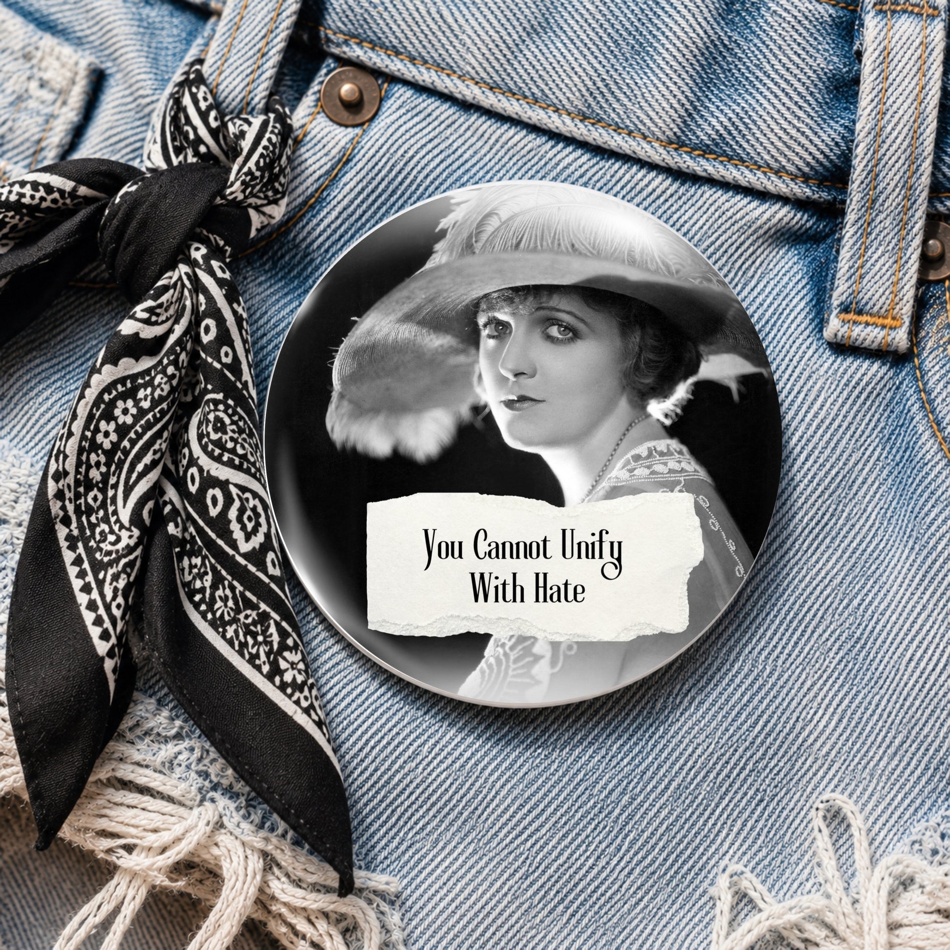 Pinback button shown on denim featuring a retro woman and the quote "You Cannot Unify With Hate"