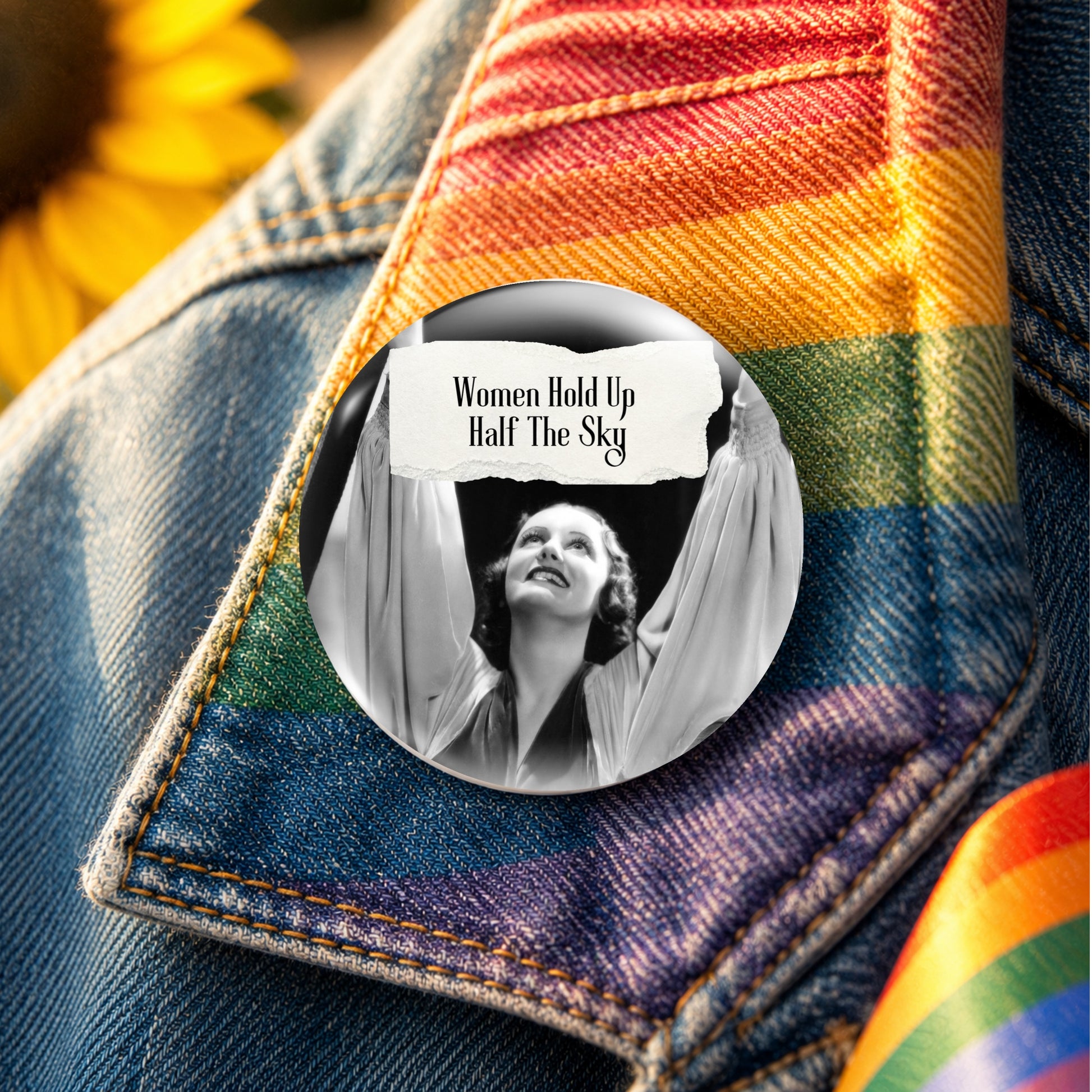 Feral retro woman pin back button with quote that says "Women Hold Up Half The Sky" shown on a rainbow denim jacket collar