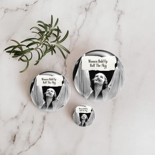 Feral retro woman pin back button with quote that says "Women Hold Up Half The Sky" with three sizes represented