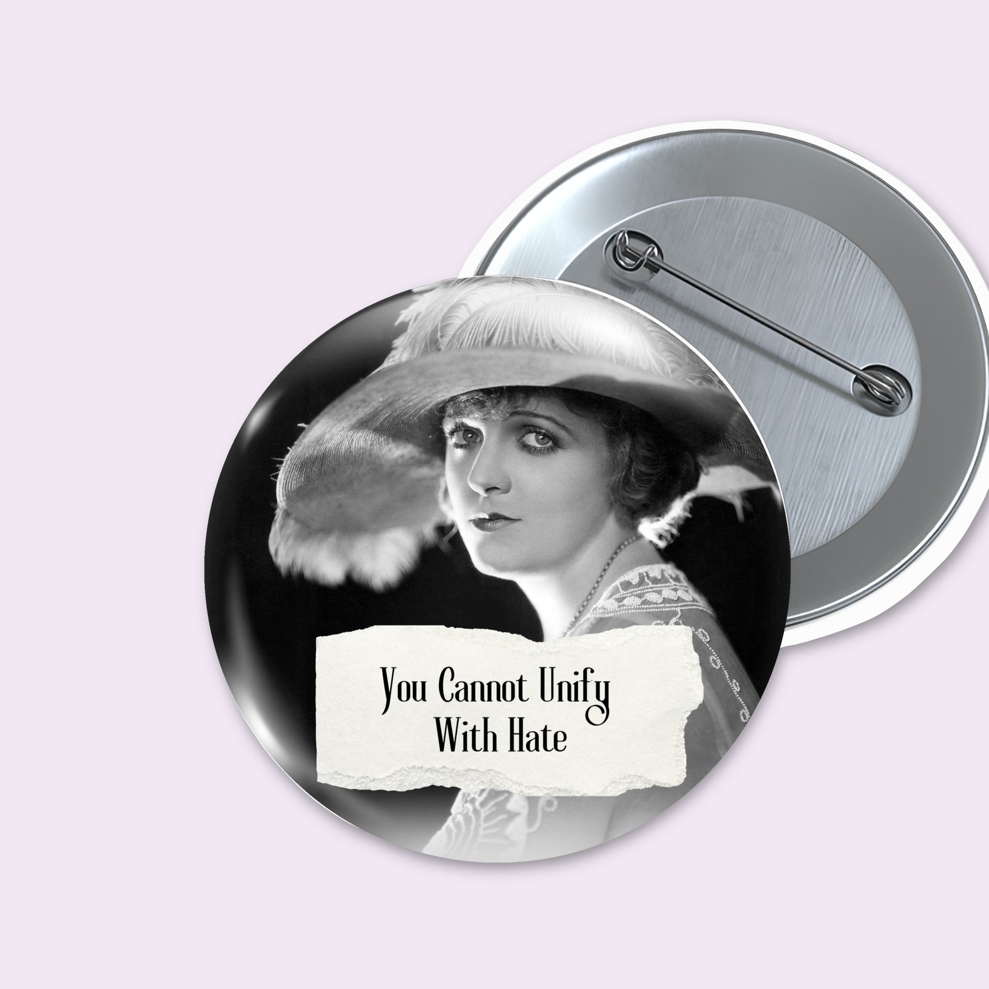 Front and back views of round pinback button on a pale lavender background. The front button shows a black-and-white portrait of a woman in a wide hat with torn-paper style text reading 'You Cannot Unify With Hate.
