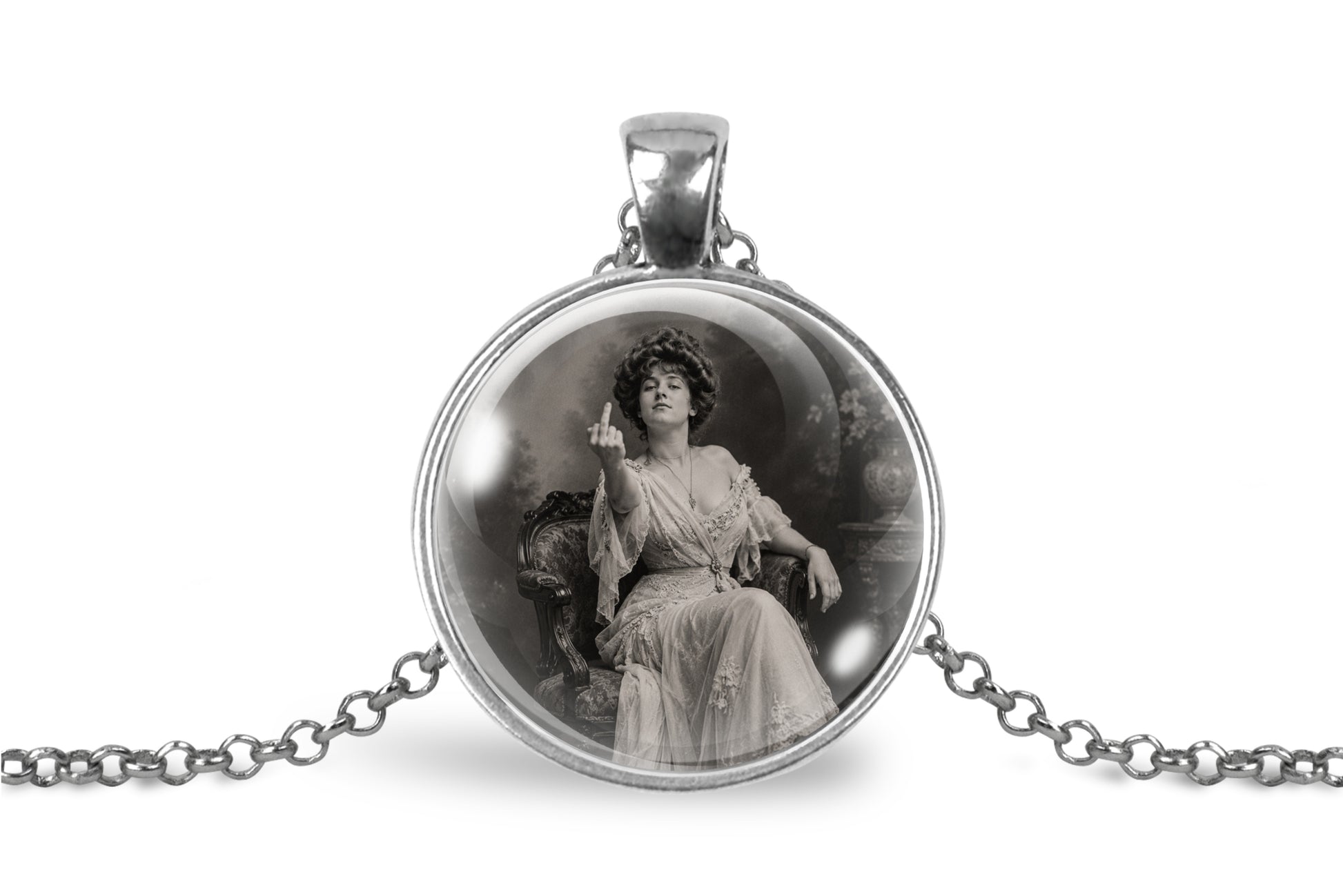 A silver-toned pendant necklace featuring a circular cabochon with a black-and-white vintage portrait of a seated woman, shown on a white background with part of the chain visible.