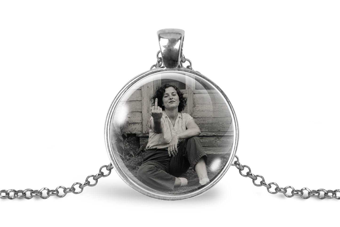 A silver round pendant necklace featuring a black and white vintage-style photo of a seated woman, suspended from a silver chain on a white background.