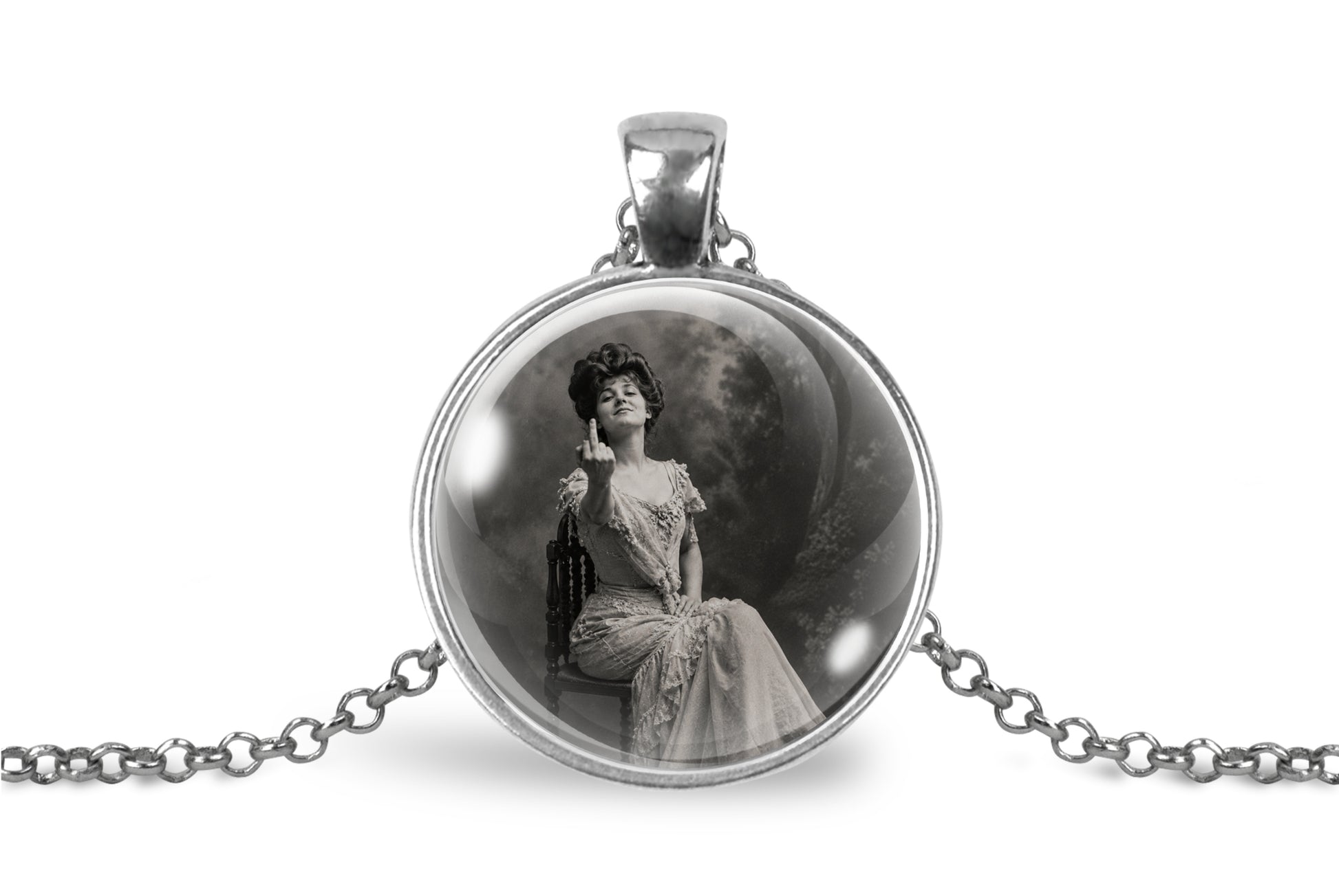 A silver pendant necklace featuring a circular glass dome with a black-and-white vintage portrait of a seated woman, suspended from a silver chain on a white background.