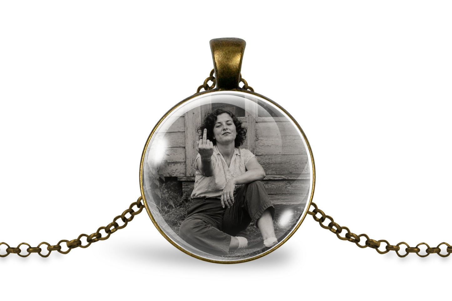 An antique bronze round pendant necklace featuring a black and white photo of a woman sitting on wooden steps and gesturing with her middle finger, displayed on a clean white background.