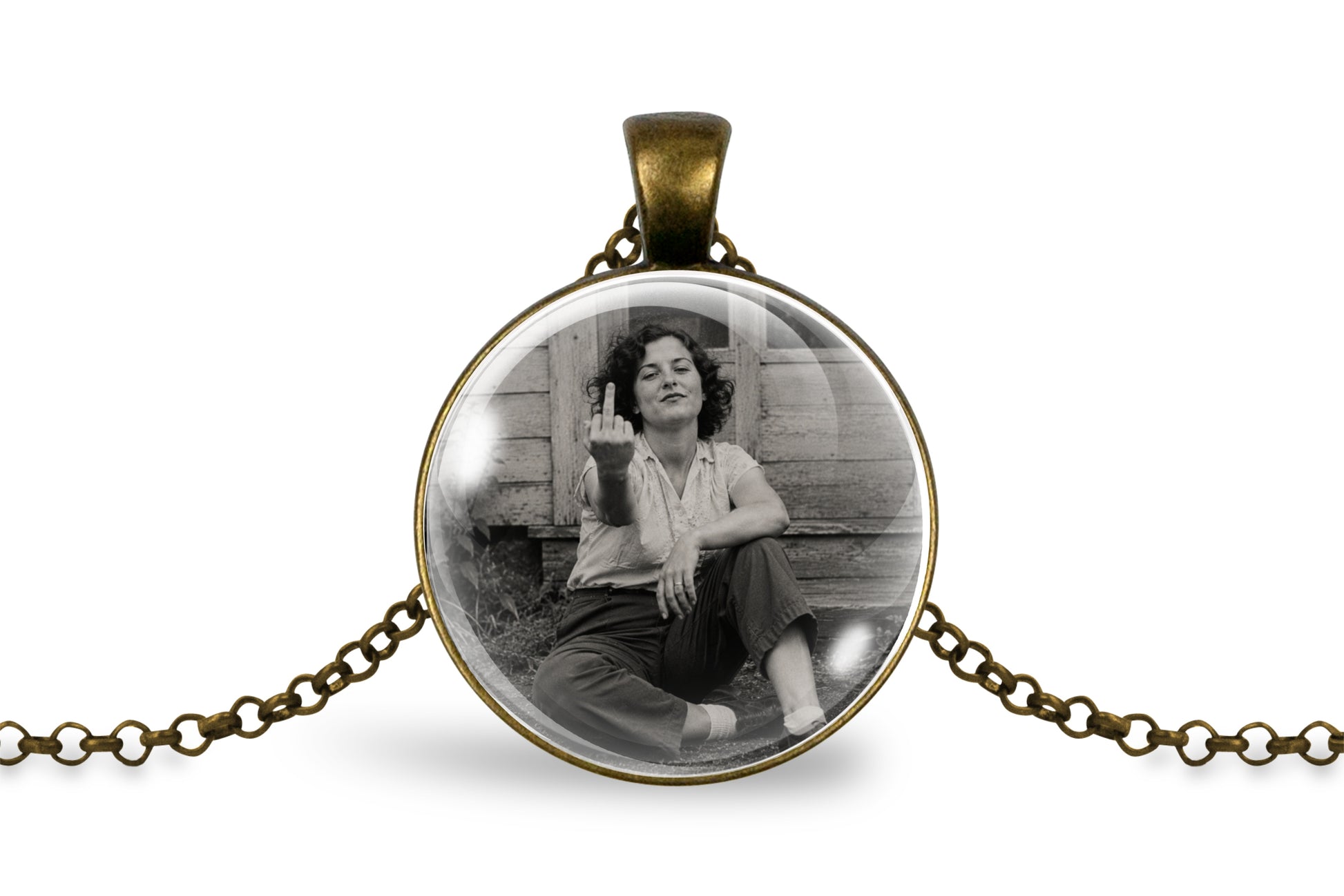 An antique bronze round pendant necklace featuring a black and white photo of a woman sitting on wooden steps and gesturing with her middle finger, displayed on a clean white background.