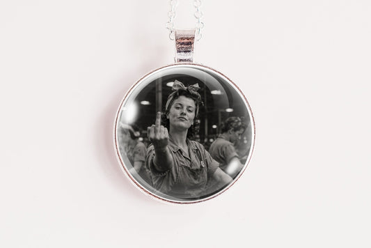 A silver circular pendant necklace featuring a black and white portrait photo of a woman, suspended from a thin white chain against a plain white background.