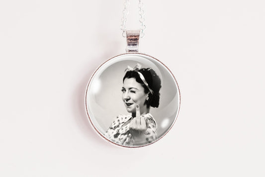 A silver circular pendant necklace featuring a black and white portrait photo of a woman, suspended against a plain white background.