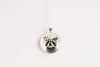 Necklace with a pendant featuring a raccoon wearing a flower crown shown against a white background
