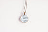 Necklace with a pendant featuring text from an upcycled book page, on a white background