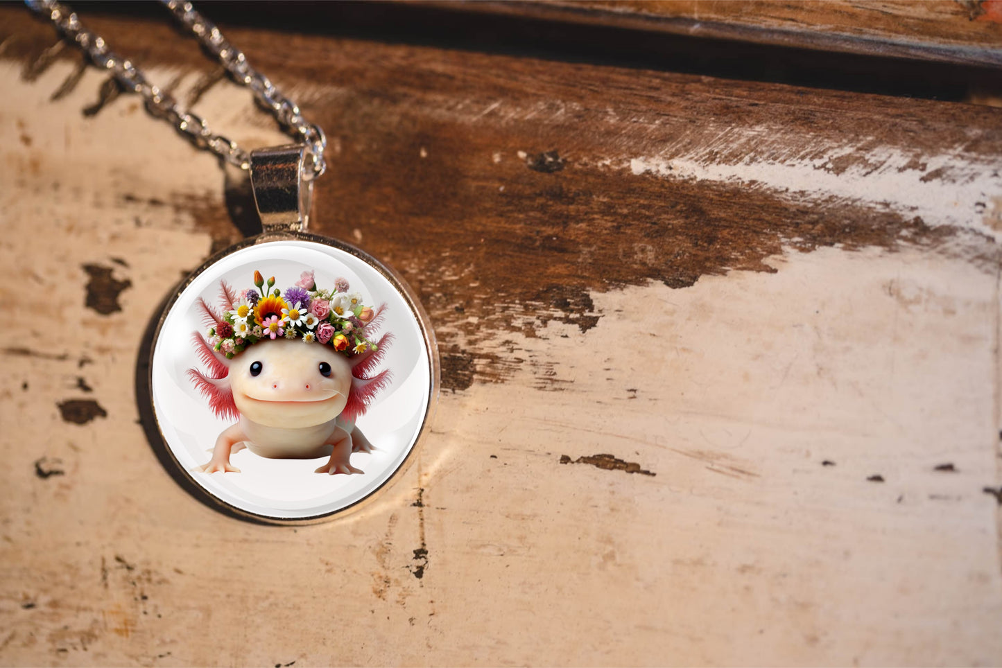 Necklace with pendant featuring a cute axolotl with flowers on a wooden surface