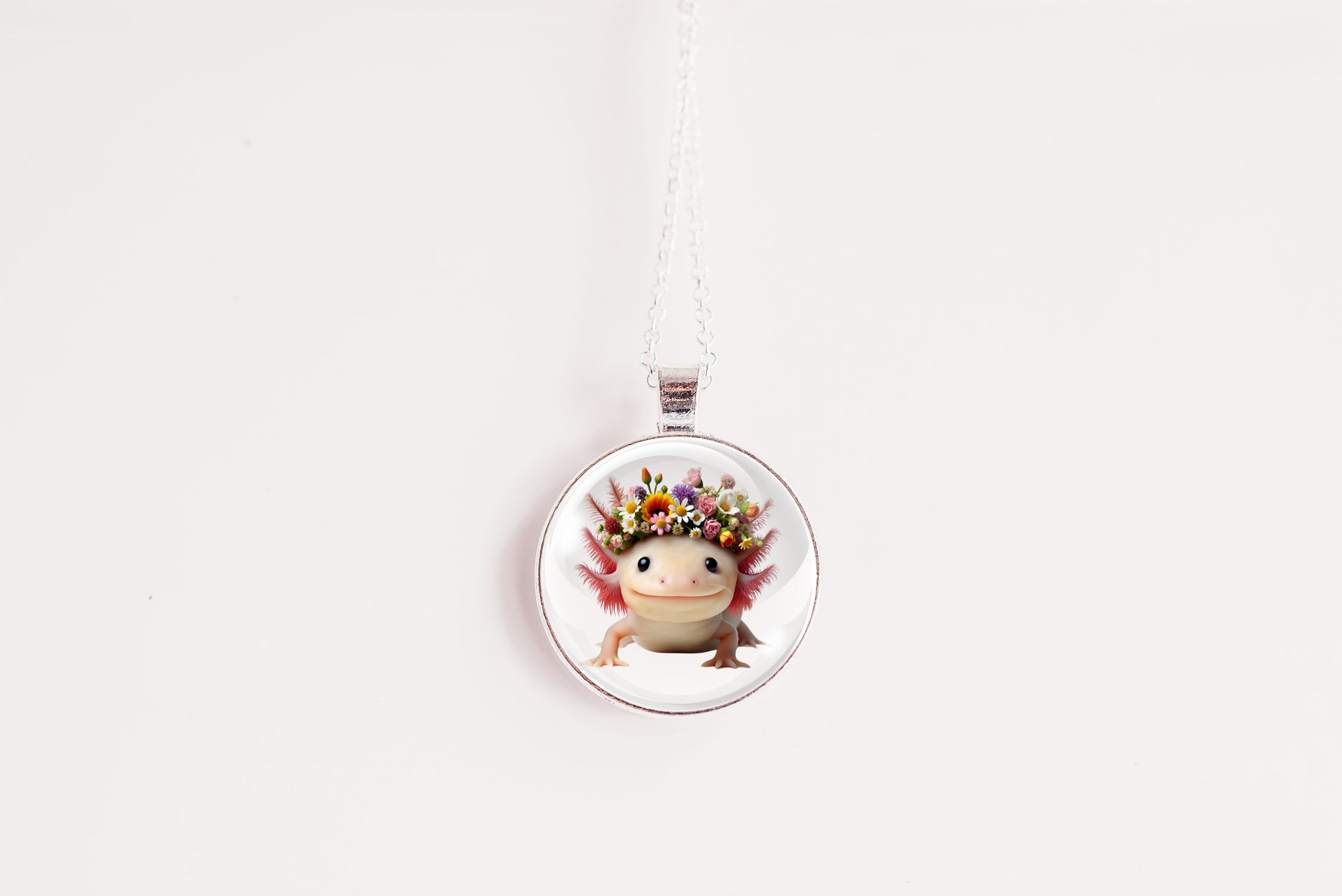 Necklace with a round pendant featuring a cute kawaii axolotl wearing a flower crown on a white background