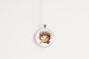 Necklace with a round pendant featuring a cute kawaii axolotl wearing a flower crown on a white background