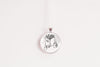 Necklace with a silver-plated pendant featuring an image of a hand holding a book with branches coming out of the top and a cup, on a white background
