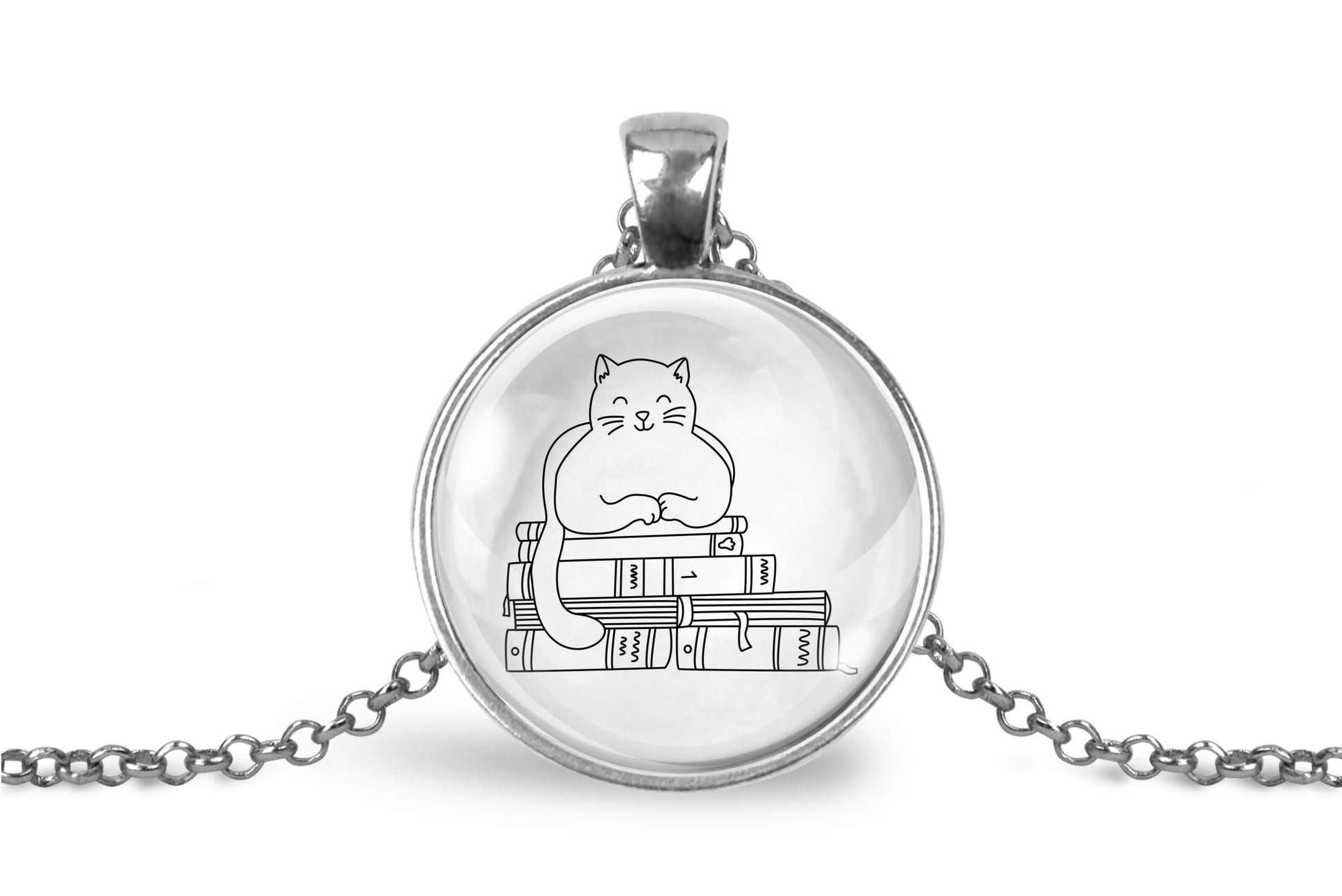 Glass cabochon pendant featuring a black line drawing of a cat sitting on stacked books