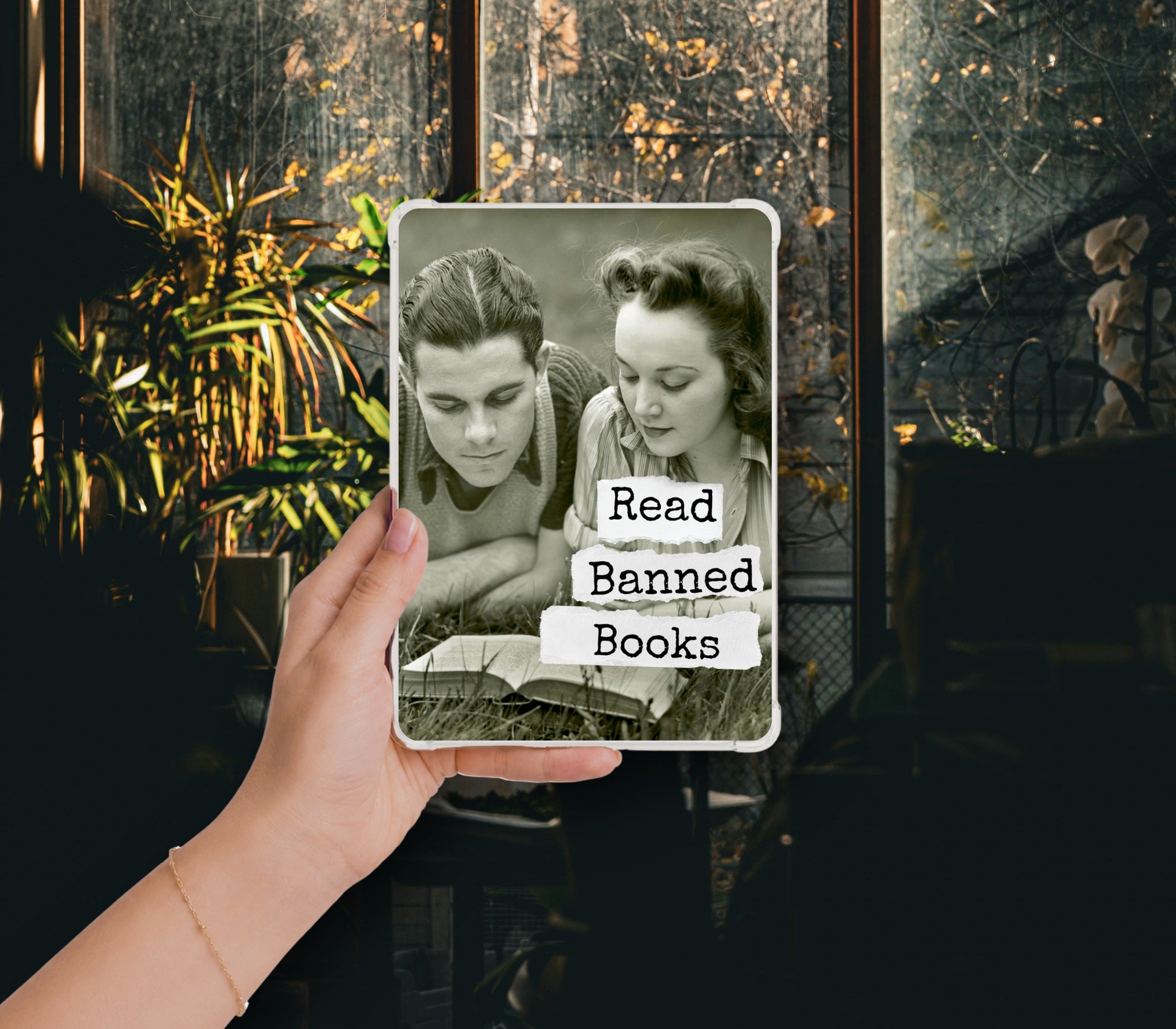 Read Banned Books printable Kindle clear case insert featuring a young vintage couple reading together, shown in a clear Kindle case held against a dark botanical background.