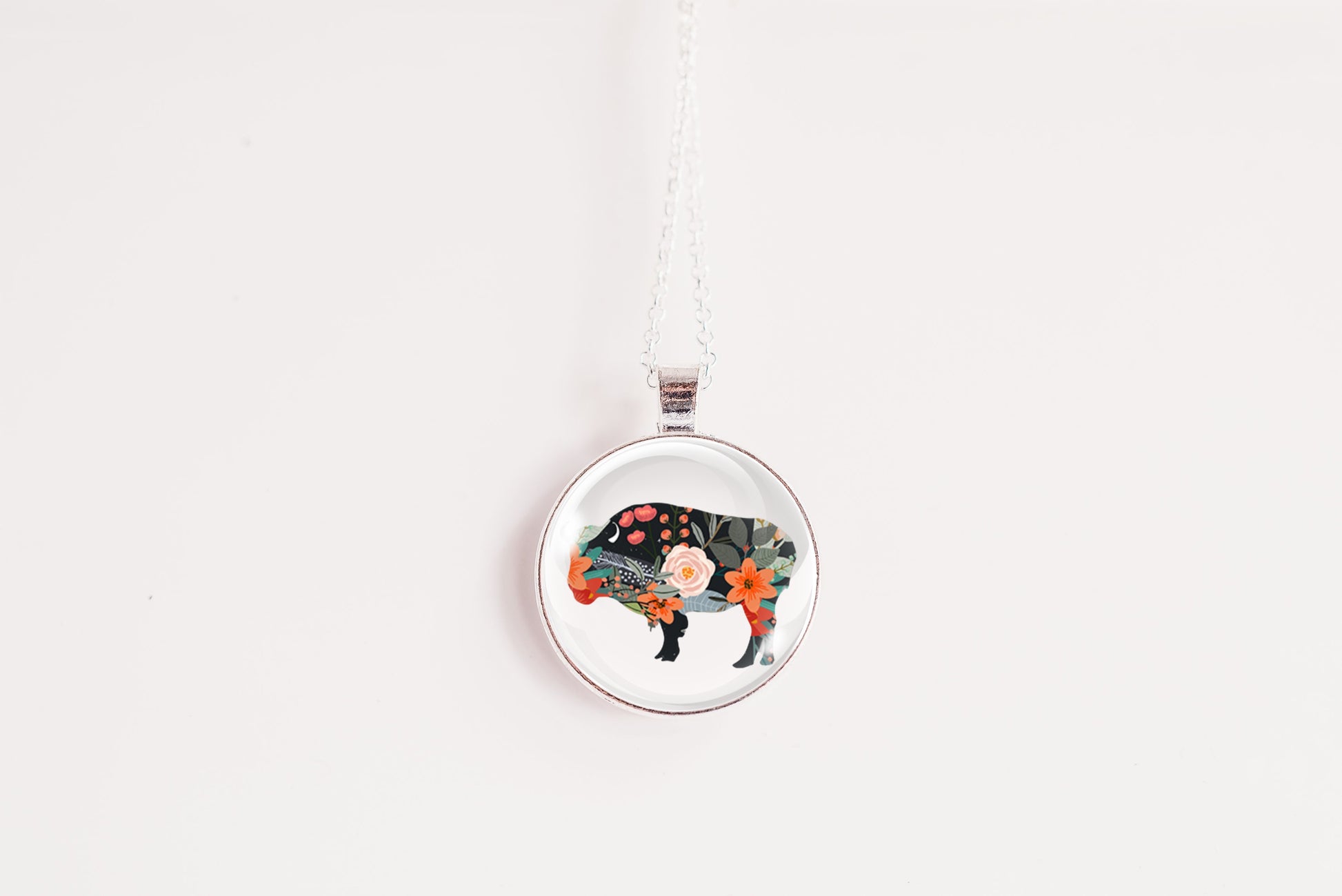Round pendant with a floral bison design on a white background