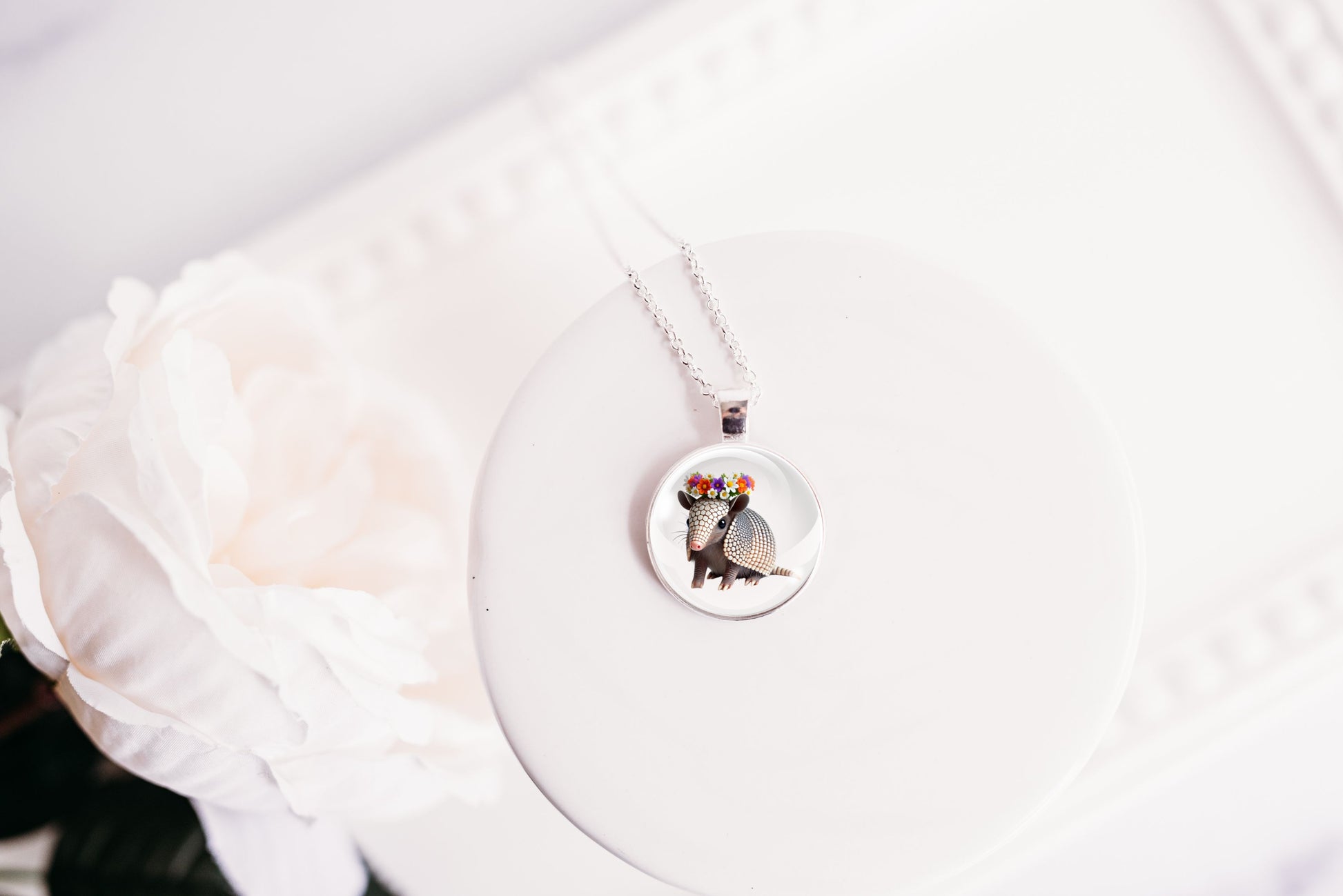Necklace with a pendant featuring an armadillo design on a white background