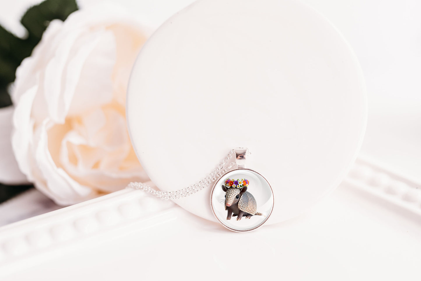 Necklace with a pendant featuring an armadillo design on a white background
