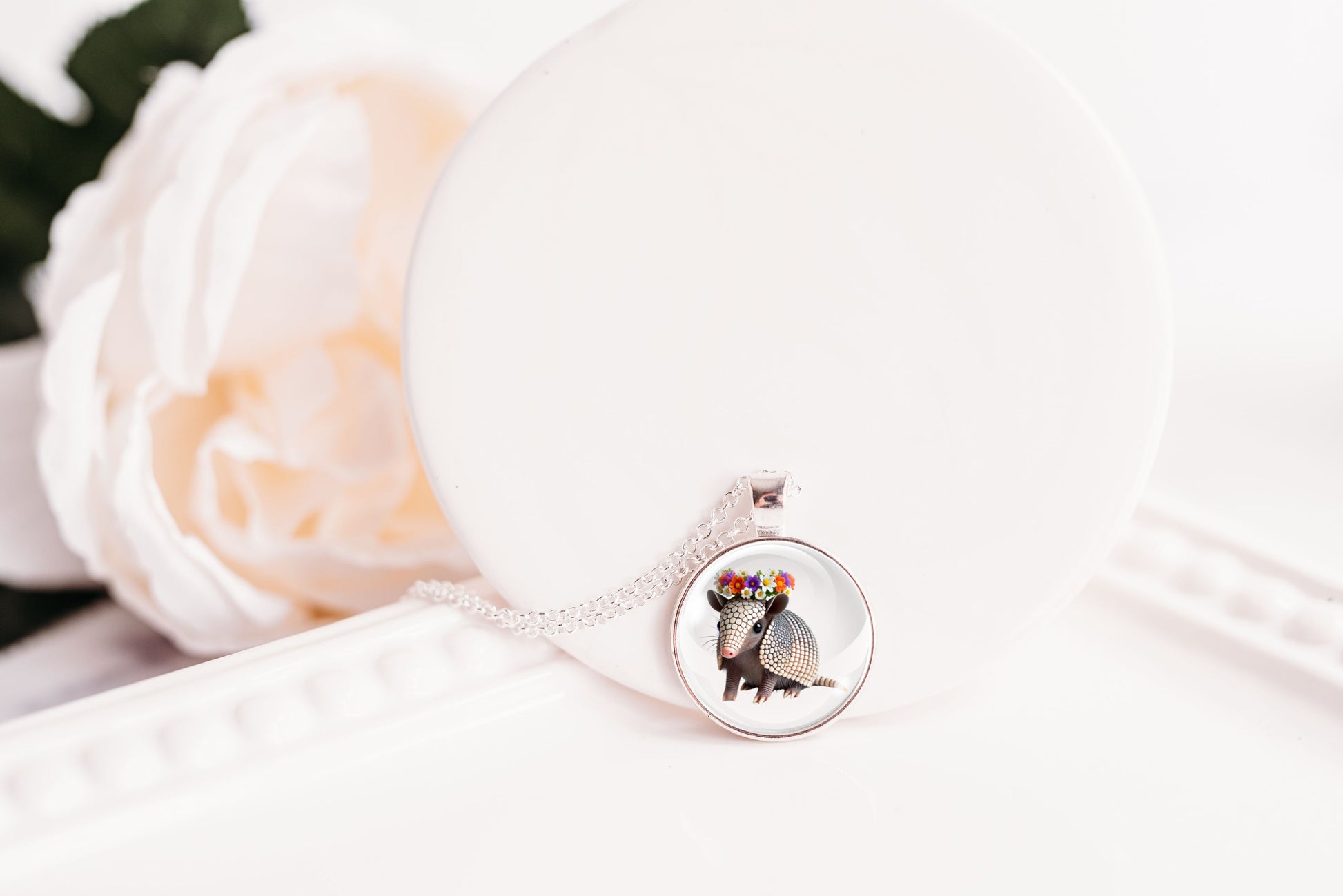 Necklace with a pendant featuring an armadillo design on a white background