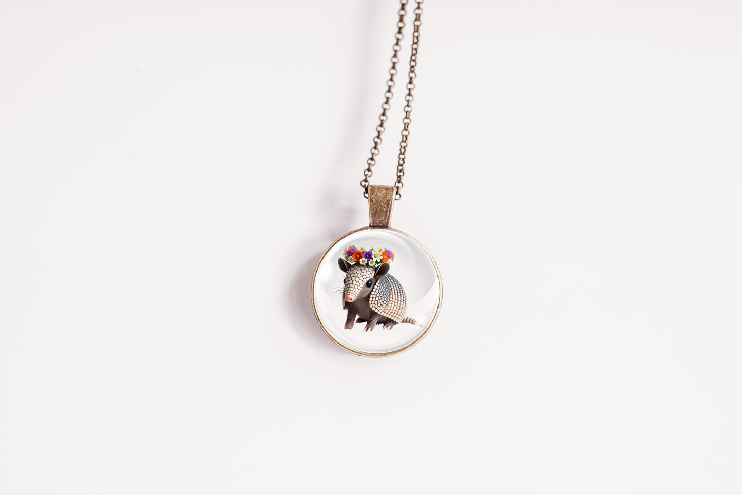 Necklace with a pendant featuring an armadillo design on a white background