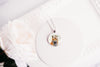 Necklace with a pendant featuring fox wearing a flower crown on a white background