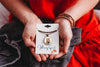Person holding a necklace with 'Whimsy Spirit' packaging