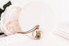 Necklace with a pendant featuring a fox wearing a flower crown on a white surface with flowers - Whimsy Spirit Shop