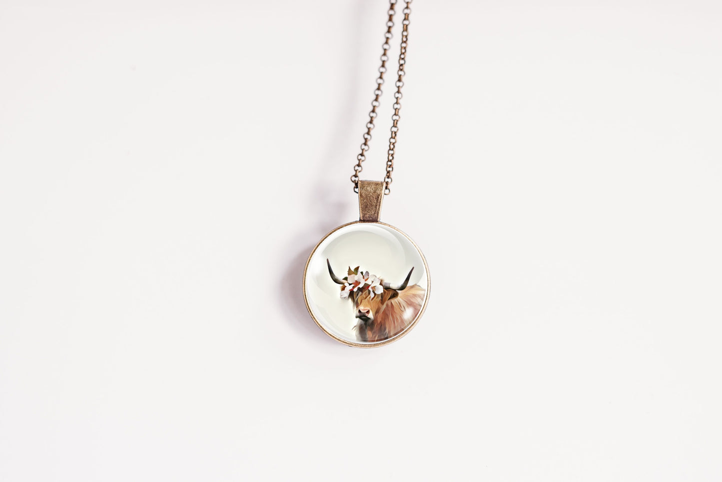 Necklace with a pendant featuring a highland cow design on a white background