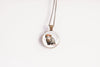 Necklace with a pendant featuring an image of an opossum wearing a flower crown on a white background