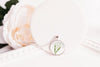 Lily of the Valley Necklace silver pendant styled beside a peach rose, May birth flower jewelry