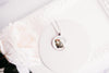 Necklace with a pendant featuring an image of an opossum on a white surface
