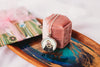 Necklace with an otter pendant on a wooden tray with a pink velvet box