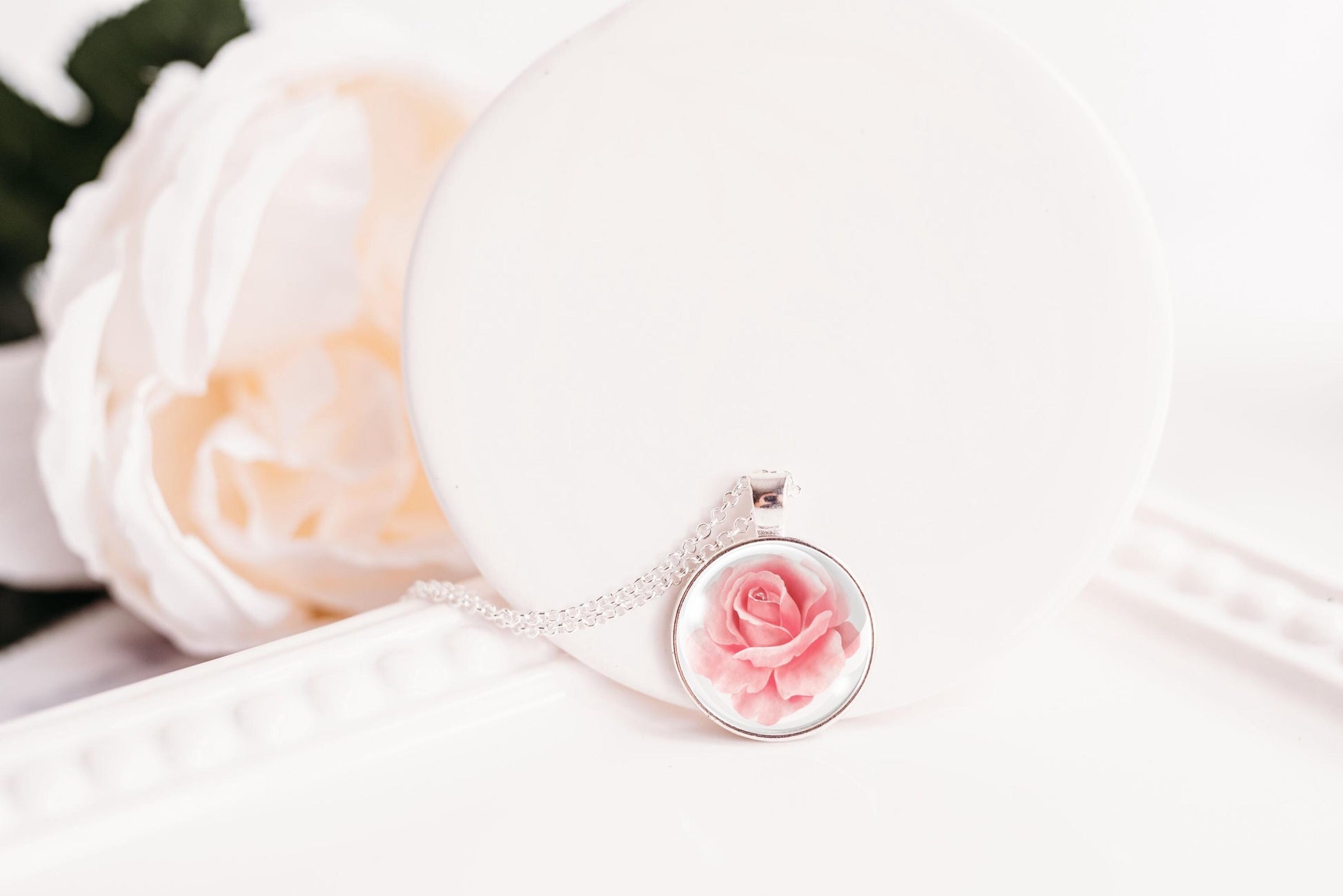 Pink rose birth flower glass cabochon pendant on white surface with pink rose – bronze-plated chain