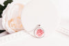 Pink rose birth flower glass cabochon pendant on white surface with pink rose – bronze-plated chain