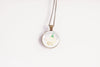 Honeysuckle birth flower pendant close-up on bronze-plated chain – June birth flower glass cabochon