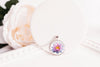 Water lily birth flower glass cabochon pendant on white surface with flowers – bronze-plated chain