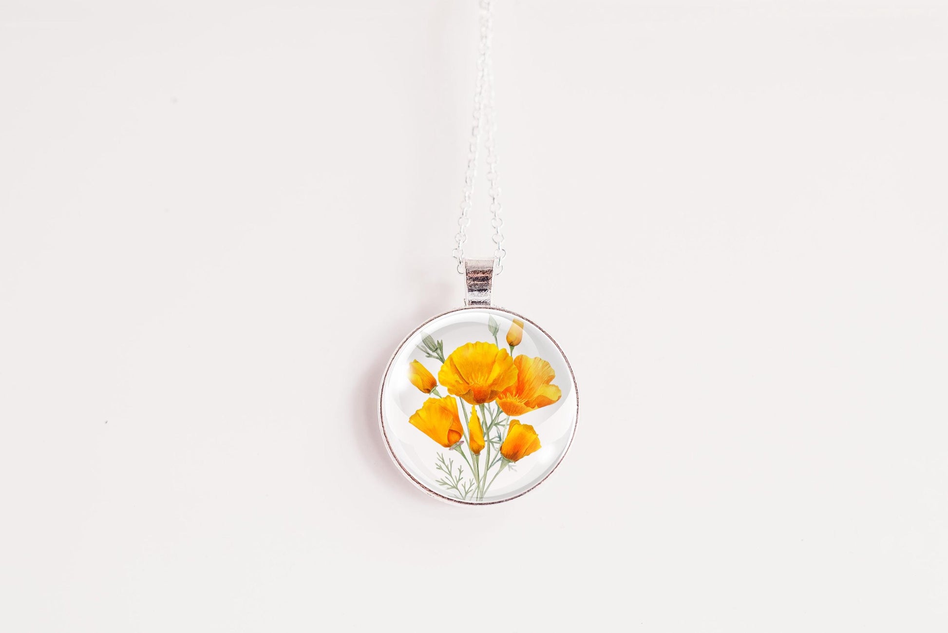 Necklace with a floral California poppies image pendant on a white background