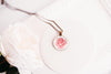 Rose birth flower necklace close-up detail – glass cabochon pendant with pink rose illustration