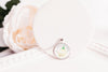 Honeysuckle birth flower glass cabochon pendant on white surface with flowers – silver-tone chain