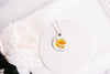 Necklace with a floral California poppies image pendant on a white background