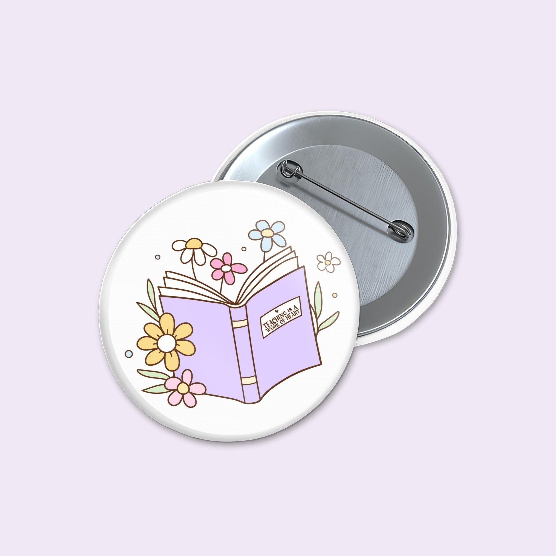 Button badge with a design of an open book and flowers on a light purple background