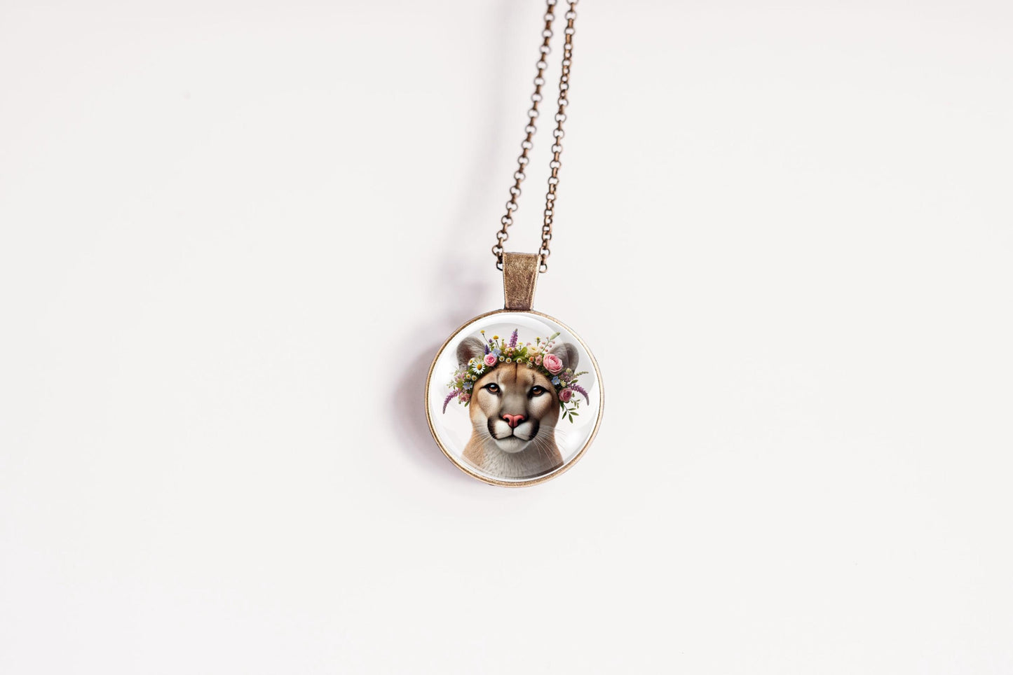 Necklace with a pendant featuring a lioness's face with floral crown on a white background