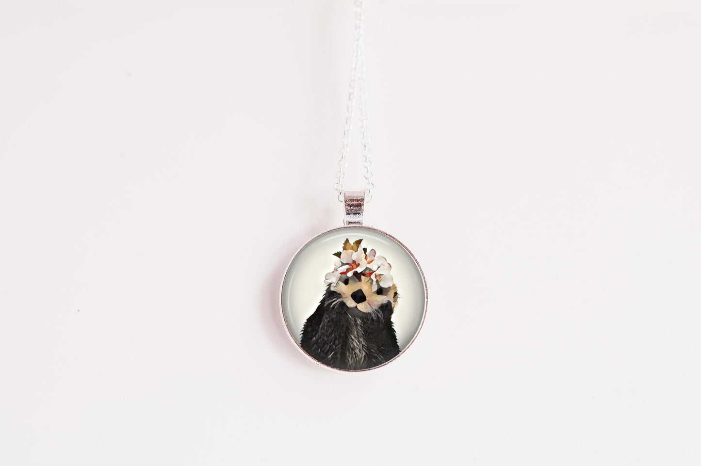 Round pendant with an otter image on a white background