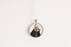 Round pendant with an otter image on a white background